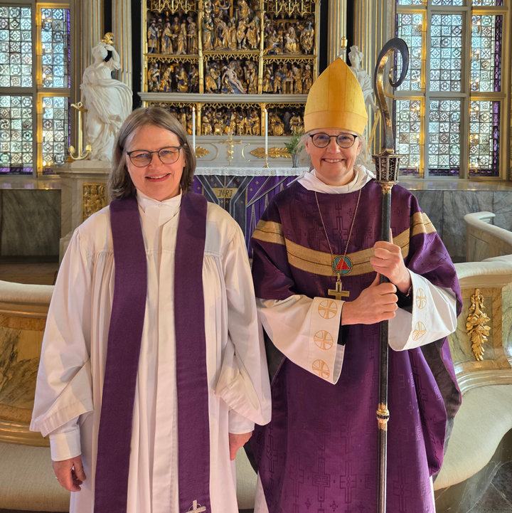 En präst och en biskop framför en altartavla