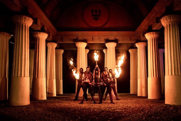 Bild på bandet Watain i en pelarsal med brinnande facklor