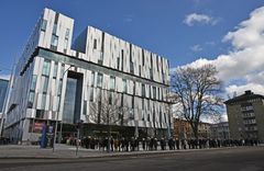 Lång kö av besökare utanför Uppsala Konsert & Kongress en solig dag.