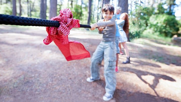 Foto av barn som ler och drar i ett rep.