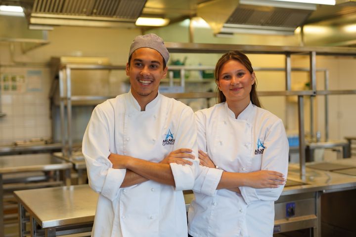 Två ungdomar står bredvid varandra och ser glada ut.