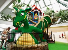 En stor grön LEGO-drake med breda vingar inomhus på Hotel LEGOLAND i Billund. Foto: LEGOLAND® Billund Resort