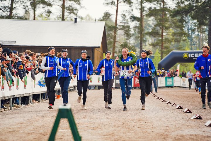 Malin Agervig Kristiansson springer tillsammans med sina lagompisar över mållinjen som segerare i Tiomila 2026.