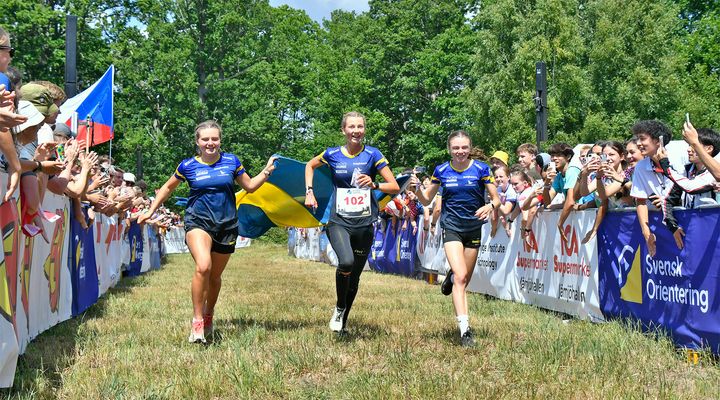 Tilia Olsson, Felicia Persson och Freja Hjerne springer mot mål och JVM-guld i stafett.