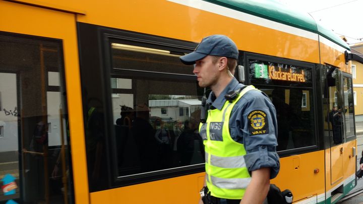 En biljettkontrollant utanför en buss.