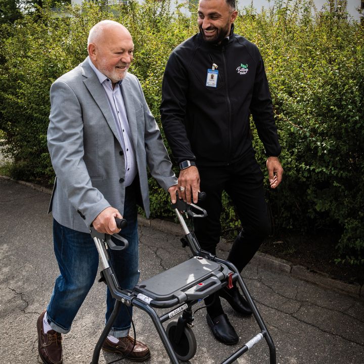 Äldre man med rullator får hjälp av serviceförare