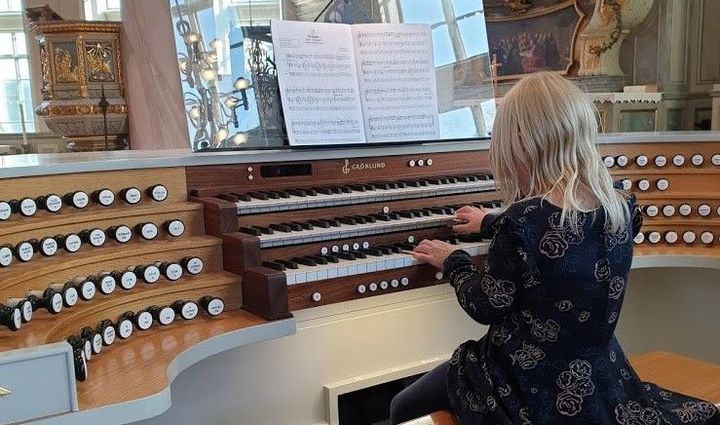 Bild på en flicka vid en orgel