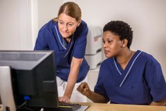 Sjukvårdspersonal diskuterar vid dator