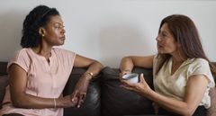 Två kvinnor samtalar i en soffa