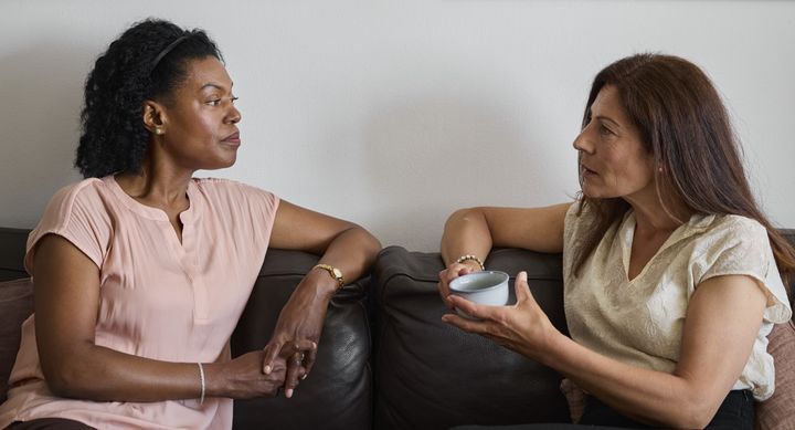 Två kvinnor samtalar i en soffa