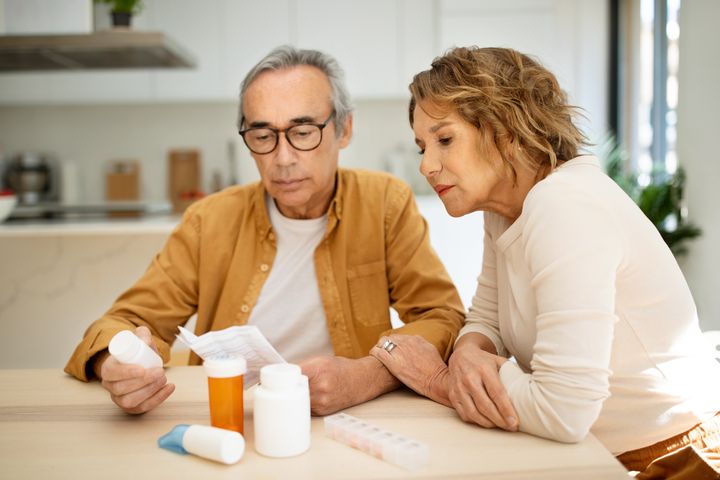 Ett äldre par granskar läkemedelsförpackningar och dess information