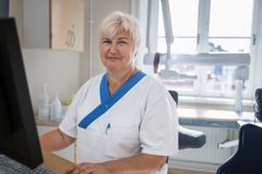 Alt-text: Sjukvårdspersonal i vårdmiljö sitter vid en dator.