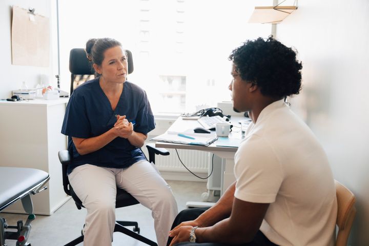 Vårdpersonal samtalar med patient på en mottagning.