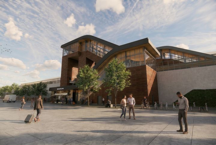 En digital bild som föreställer den tågstation som ska byggas, med dämpade och naturnära färger.