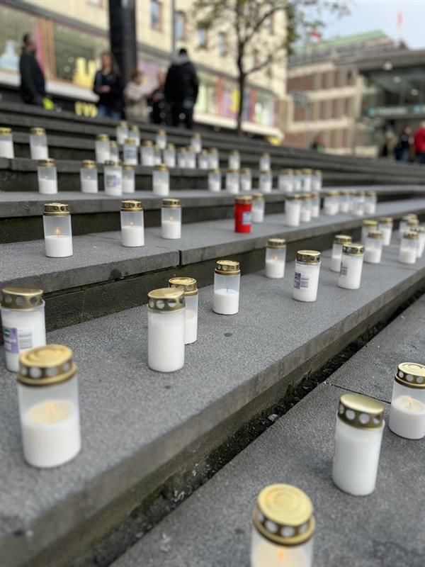 Ett flertal tända ljuslyktor placerade på trappsteg utomhus.