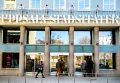 Bild på entrén till Uppsala stadsteater med besökare som går in.