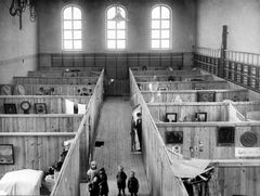 Nödbostäder, inkvartering i Polishusets gymnastiksal på Kungsholmsgatan. I dörren står Jonas Sture Domeij (född 1911) i plommonstop och till vänster i korridoren hans tre småsyskon: Inez äldst, systern Rut och Åke yngst.