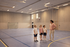 Illustration barn och idrottslärare i gympasal