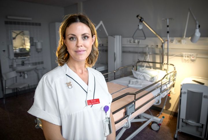 Erika Fjordkvist i sjukvårdskläder framför en patientsäng.
