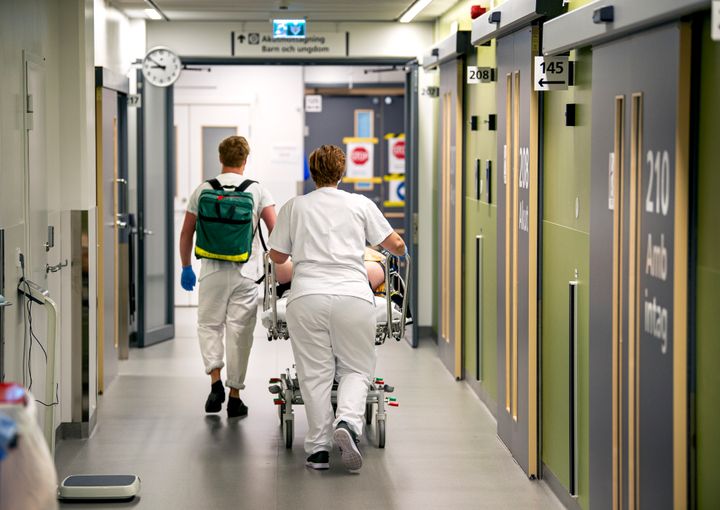 Sjukvårdspersonal kör en patient på bår.