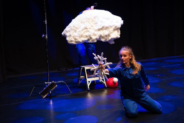 Ett scenframträdande med blått tema och ett stort konstgjort moln på en scen.