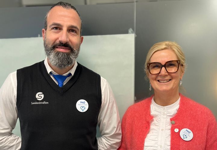 Föraren Shadi Abu Sada och enhetschef Anneli Eriksson från Svealandstrafiken, visar Hej-knappen som bland annat bärs av förare i kollektivtrafiken under kampanjperioden.