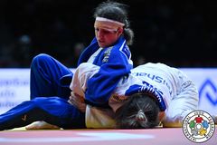 Tara i blå judodräkt håller fast sin motståndare nere i mattan.
