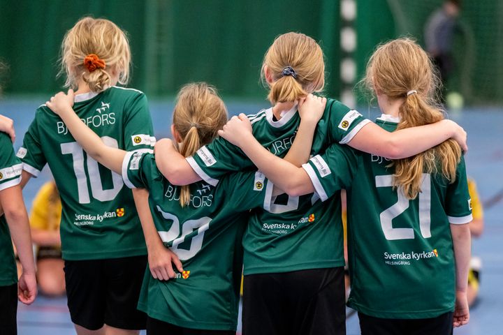 Fyra flickor håller om varandra på led efter en handbollsmatch