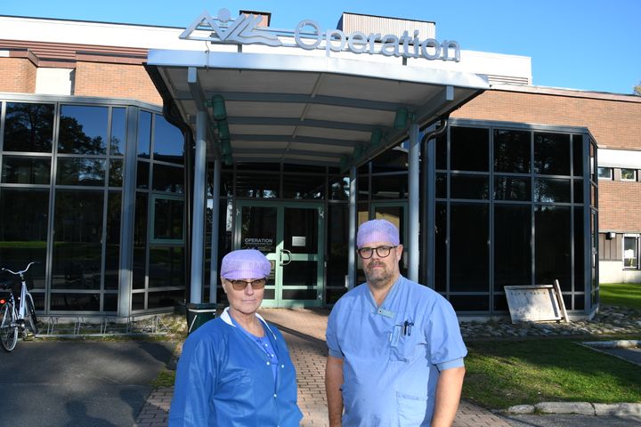 Två personer i sjukhuskläder står framför Kalix sjukhus.