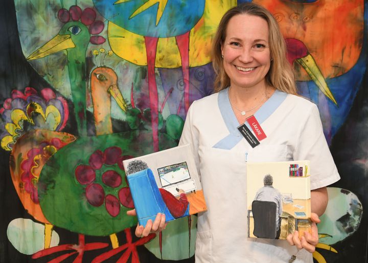 Maria Brännholm Syrjälä, specialist i allmänmedicin på Björknäs hälsocentral i Boden, med illustrationer från sin doktorsavhandling målade av konstnären Helena Öberg.