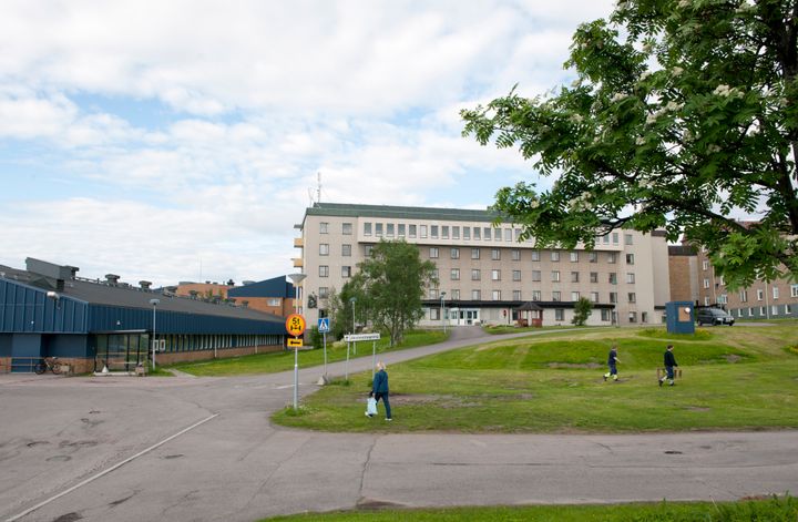 Bild av sjukhusbyggnad med en grön gräsmatta.