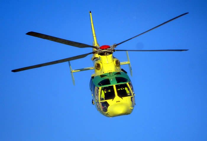 Bild på en helikopter som flyger mot en klarblå himmel.