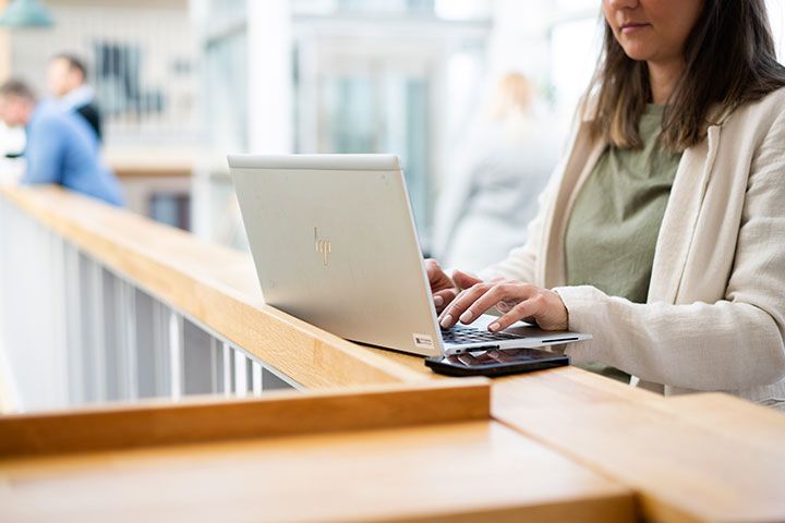 En person sitter vid en laptop och jobbar