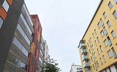 Flerbostadshus till vänster och höger om gråblå himmel