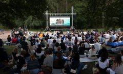 Alt text: "Mänskor tittar på en film utomhus på en stor skärm vid Lappis Beach."