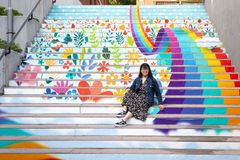 En student sitter framför en målning av trappan på Lappkärsberget.