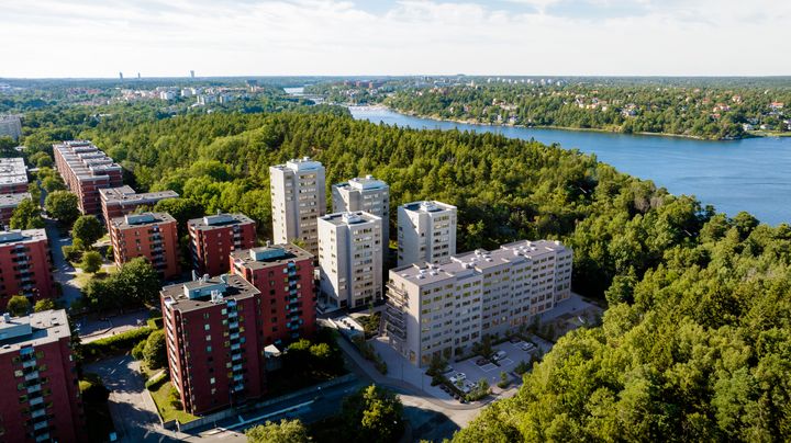 Flygbild över Lappkärrsberget med studentbostäder omgivna av grönska, nära en sjö.