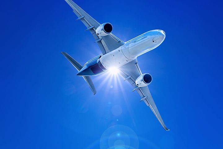 Flygplan flyger genom klarblå himmel.