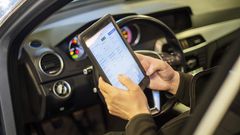 Händer som håller i en digital skärm för att registrera uppgifter under en kontrollbesiktning.