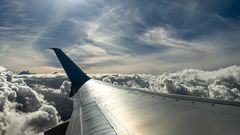 En flygplansvinge över molnen.