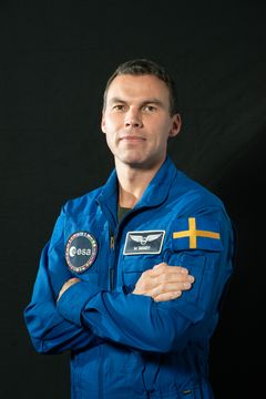 Marcus Wandt i blå astronautdräkt med svenska flaggan på armen.