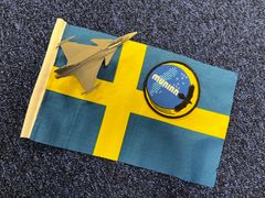 Svensk flagga, modell av Jas 39 Gripen, uppdragsmärke Muninn