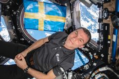 Marcus Wandt med svensk flagga i Cupolan på ISS