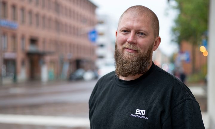 Bild på Christian i svart företagströja utanför huvudkontoret på Rosenlundsgatan