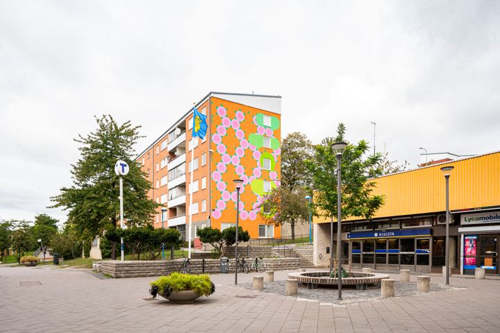 Bild på Hjulsta centrum med tunnelbana, bostäder och centrumbyggnad.