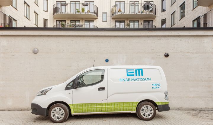 Bild på vit elbil framför cykelrummet på Telefoncentralen