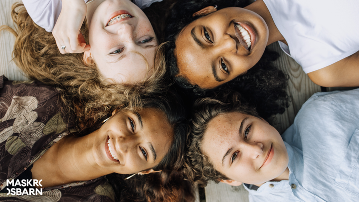 bild på barn som ligger i cirkel med huvudena mot varandra