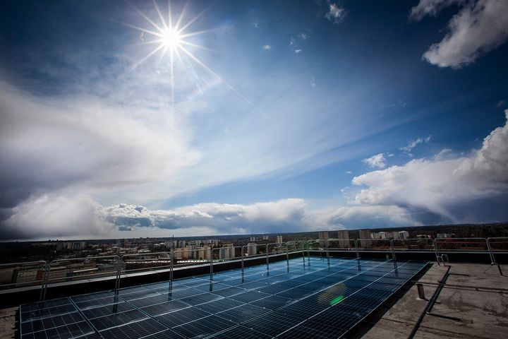 Solceller på hustak, blå himmel med moln