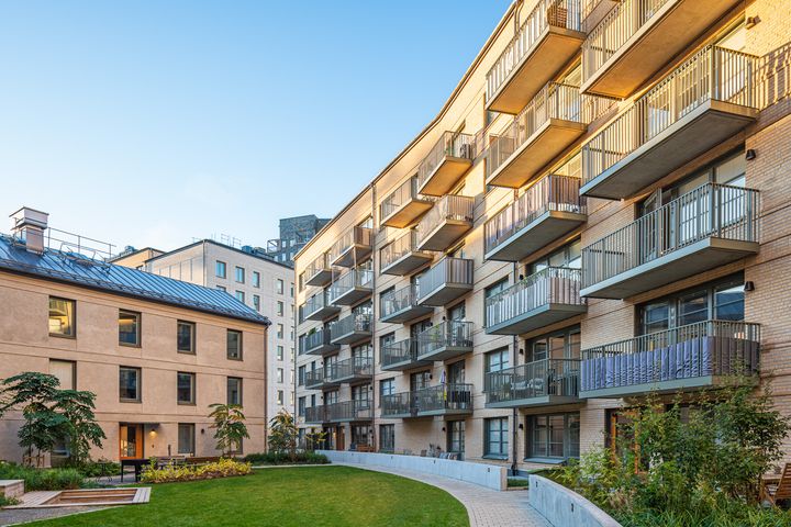 Innegård med bostadshus av gult tegel i bakgrunden