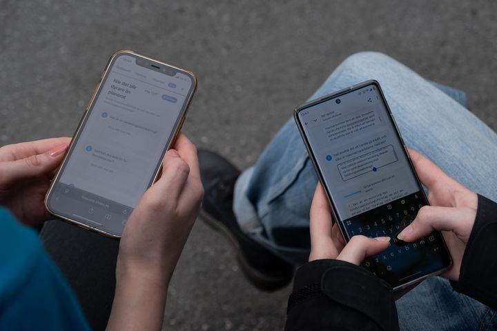 Två feriejobbar som spelar spelet BoQuest på sina mobiler.